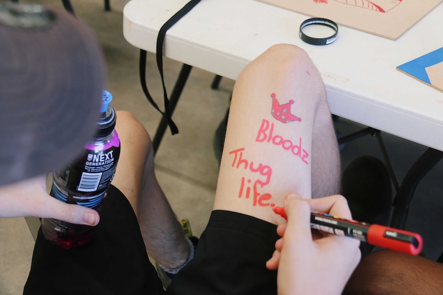 Man writing thug life on his leg