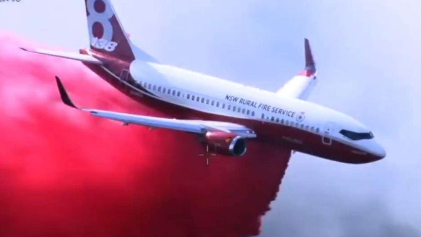 air tanker dropping red fire retardant over a bushfire