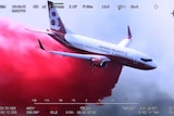 air tanker dropping red fire retardant over a bushfire