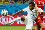 US player scores against Belgium in the 2014 FIFA World Cup with advertising in background