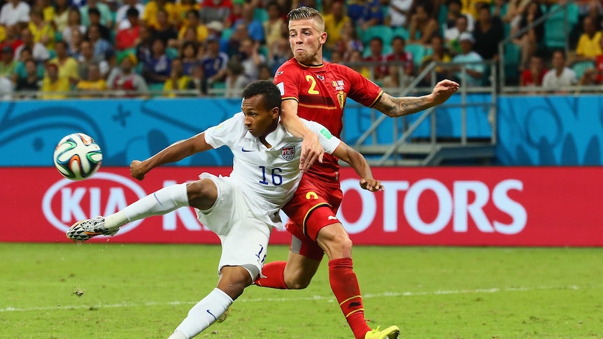 US player scores against Belgium in the 2014 FIFA World Cup with advertising in background