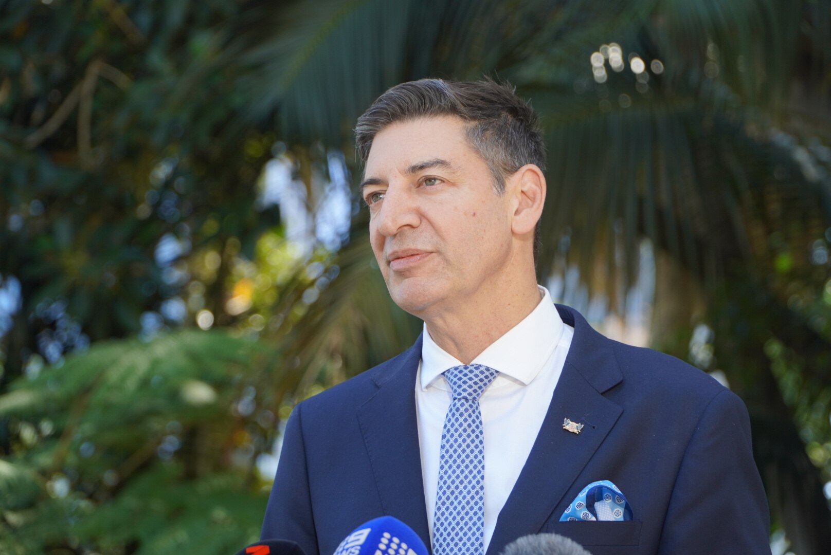 A well dressed man named Basil Zempilas looks serious at a press conference. 