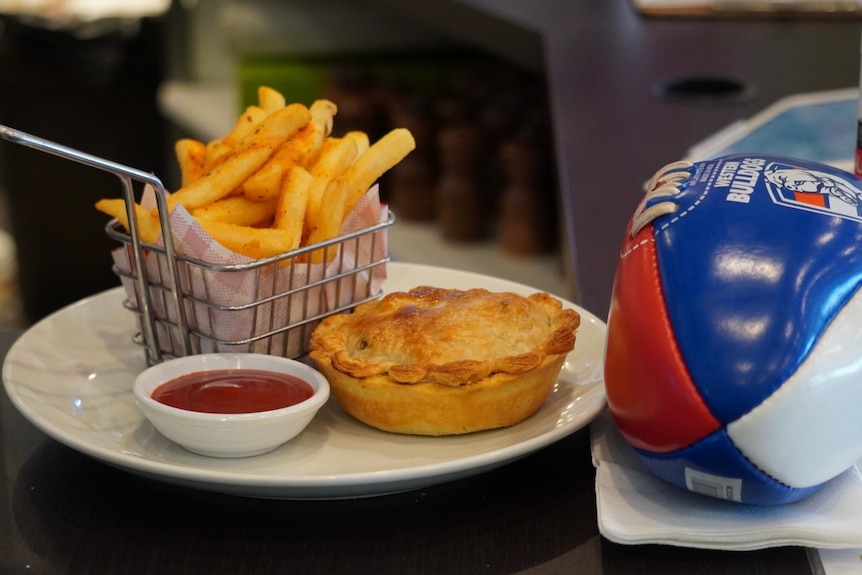 Chips, a pie and a football in Western Bulldogs colours are pictured