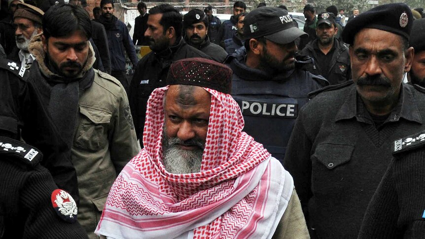 Pakistani police escorting the head of banned Lashkar-e-Jhangvi Malik Ishaq as he arrives at the high court in Lahore
