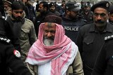 Pakistani police escorting the head of banned Lashkar-e-Jhangvi Malik Ishaq as he arrives at the high court in Lahore
