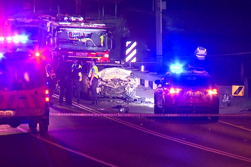 emergency services out at night next to a totalled car