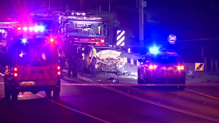 emergency services out at night next to a totalled car