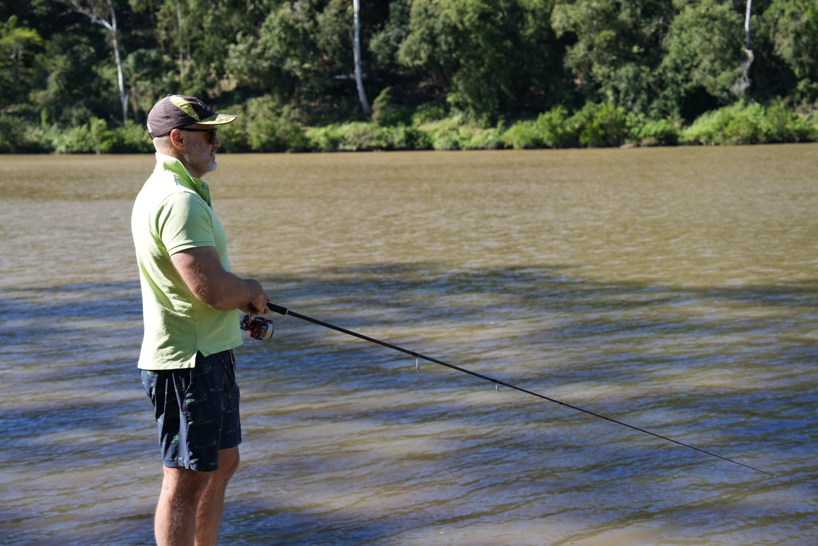 man in a green polo fishing
