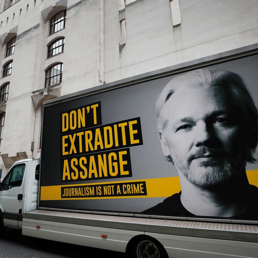 A lorry with a billboard of Julian Assange arrives at the front of a London court house.