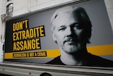 A lorry with a billboard of Julian Assange arrives at the front of a London court house.