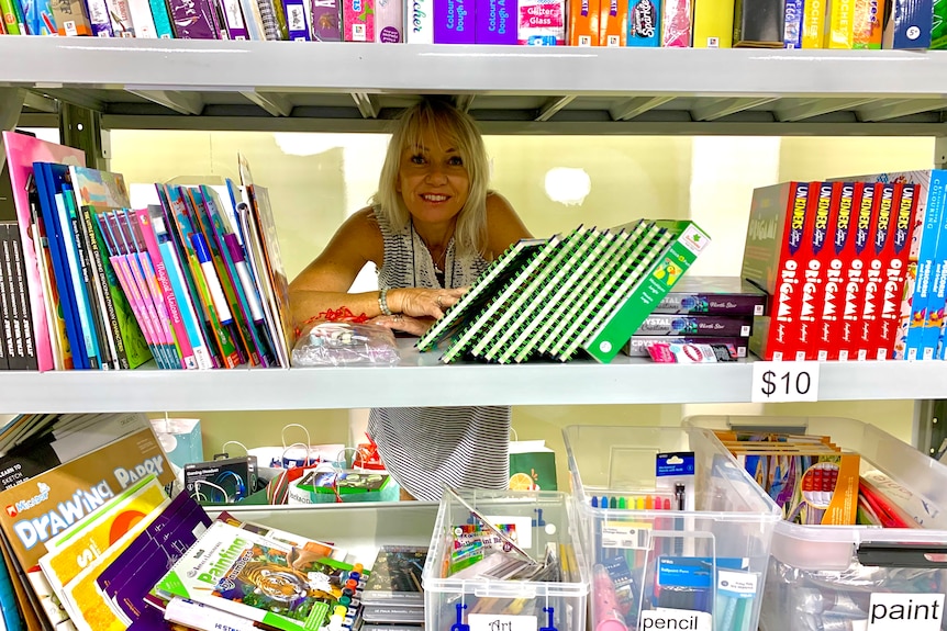 Woman standing behind shelves full of books for gifts for children in residential care
