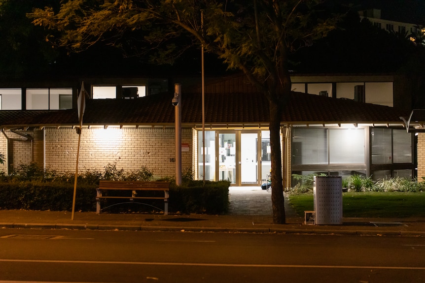 An old brick building at night with lights on inside.