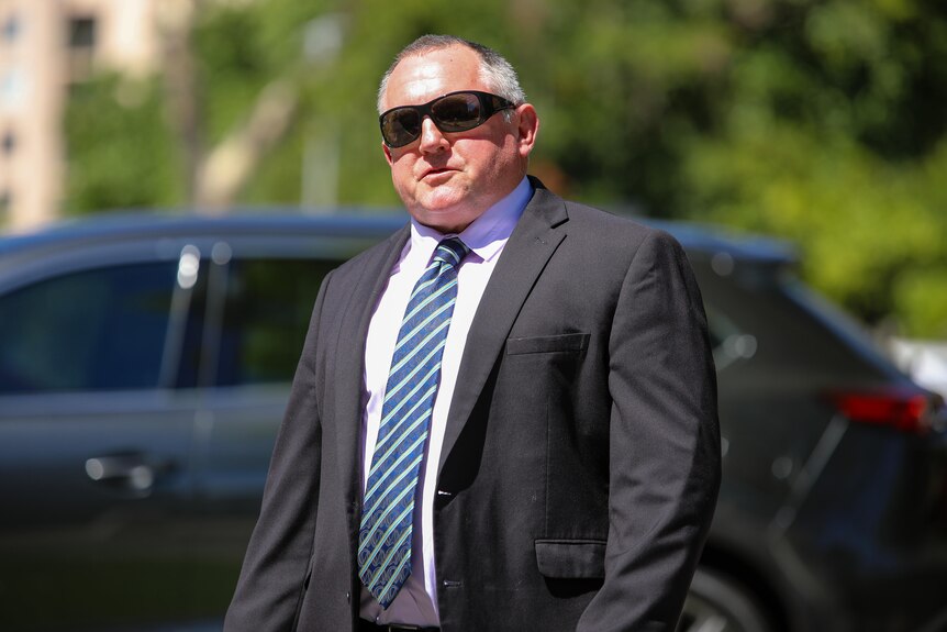 A mid-shot of WA Liberal MP Steve Thomas outside parliament wearing a suit, tie and dark sunglasses.