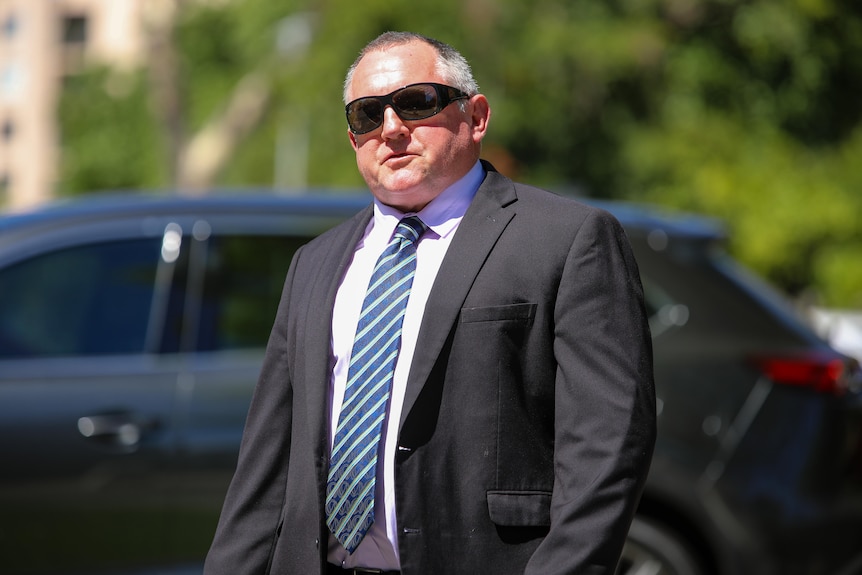 A mid-shot of WA Liberal MP Steve Thomas outside parliament wearing a suit, tie and dark sunglasses.