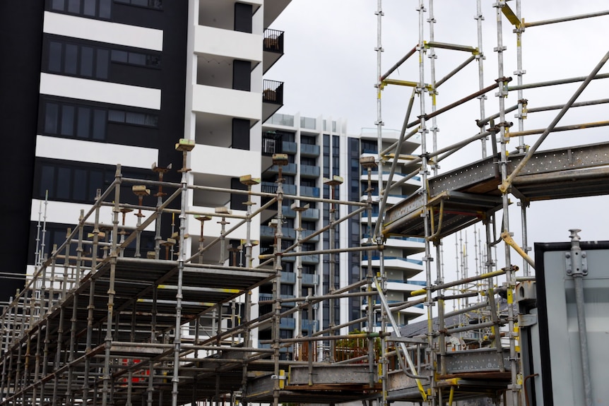 Grey scaffolding in the foreground framing existing highrises