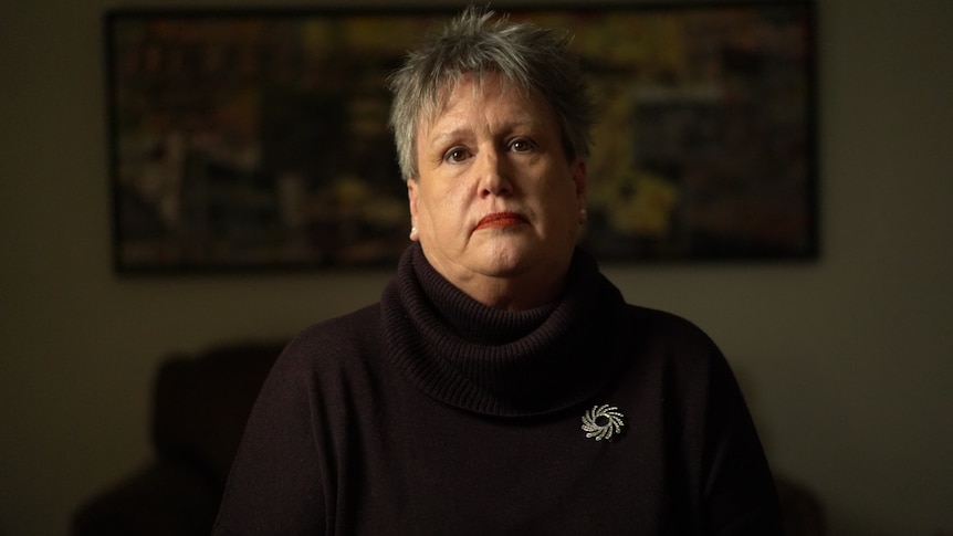 A woman with short hair wearing a dark-coloured turtle-neck.