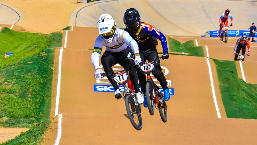 BMX riders going around a track.