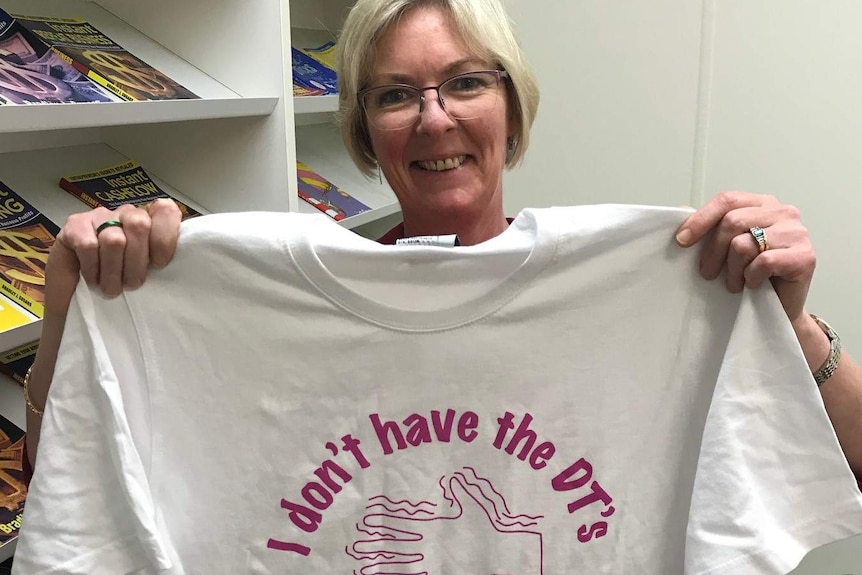 Woman holding a Parkinson's t-shirt.