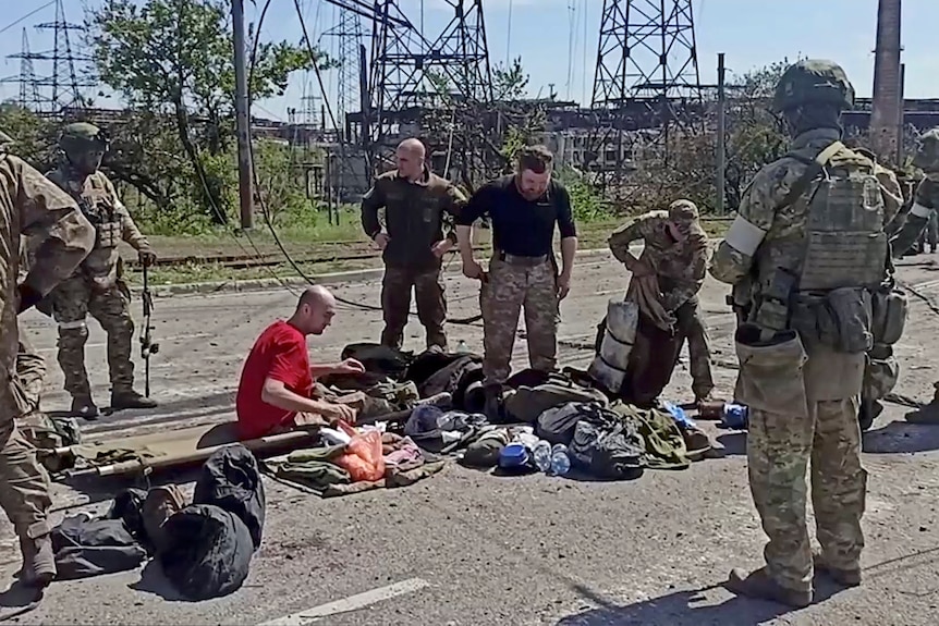 Soldiers have their belongings searched.