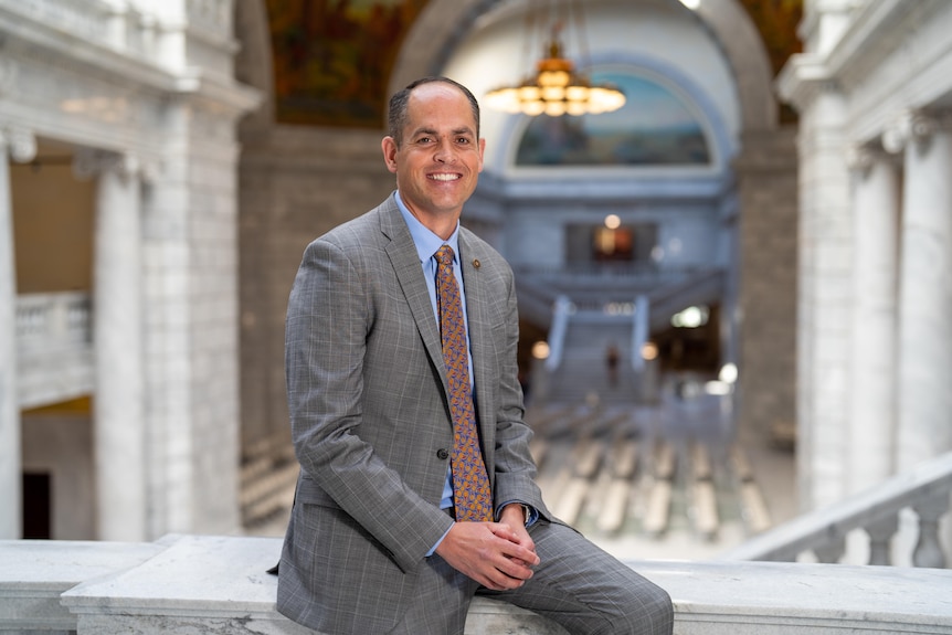 A man in a suit smiles