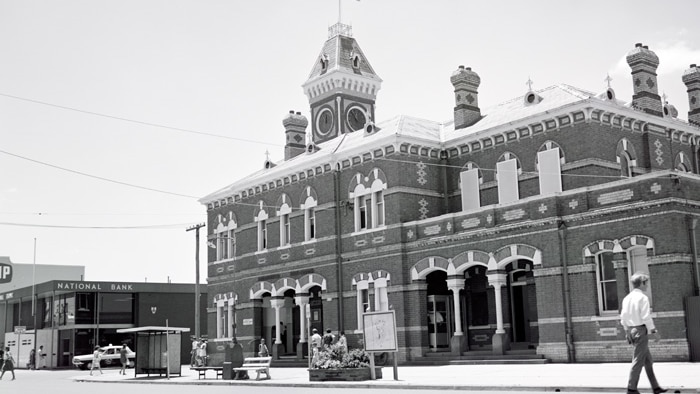 black and white image of bricked building with clock tower