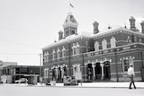 black and white image of bricked building with clock tower