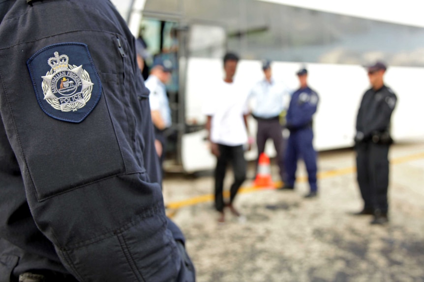 Australian Federal Police escort asylum seekers from Christmas Island to Nauru.