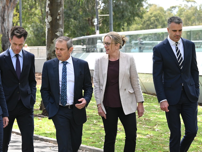 A group of politicians in suits walk together.