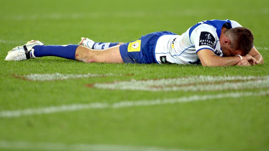 Josh Reynolds lies face down on the turf after the Dogs' loss in the 2012 NRL grand final.