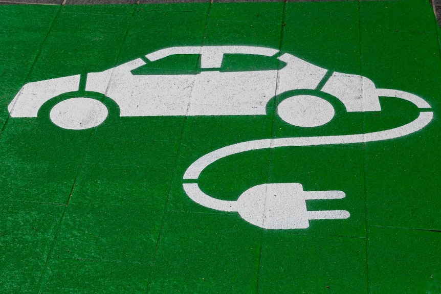 A spray-painted image of a white car with an electric cord on a green background. 