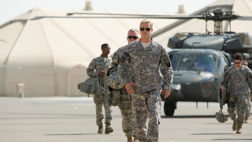 Movie still from the film War Machine, depicting Brad Pitt in character walking across an airfield.