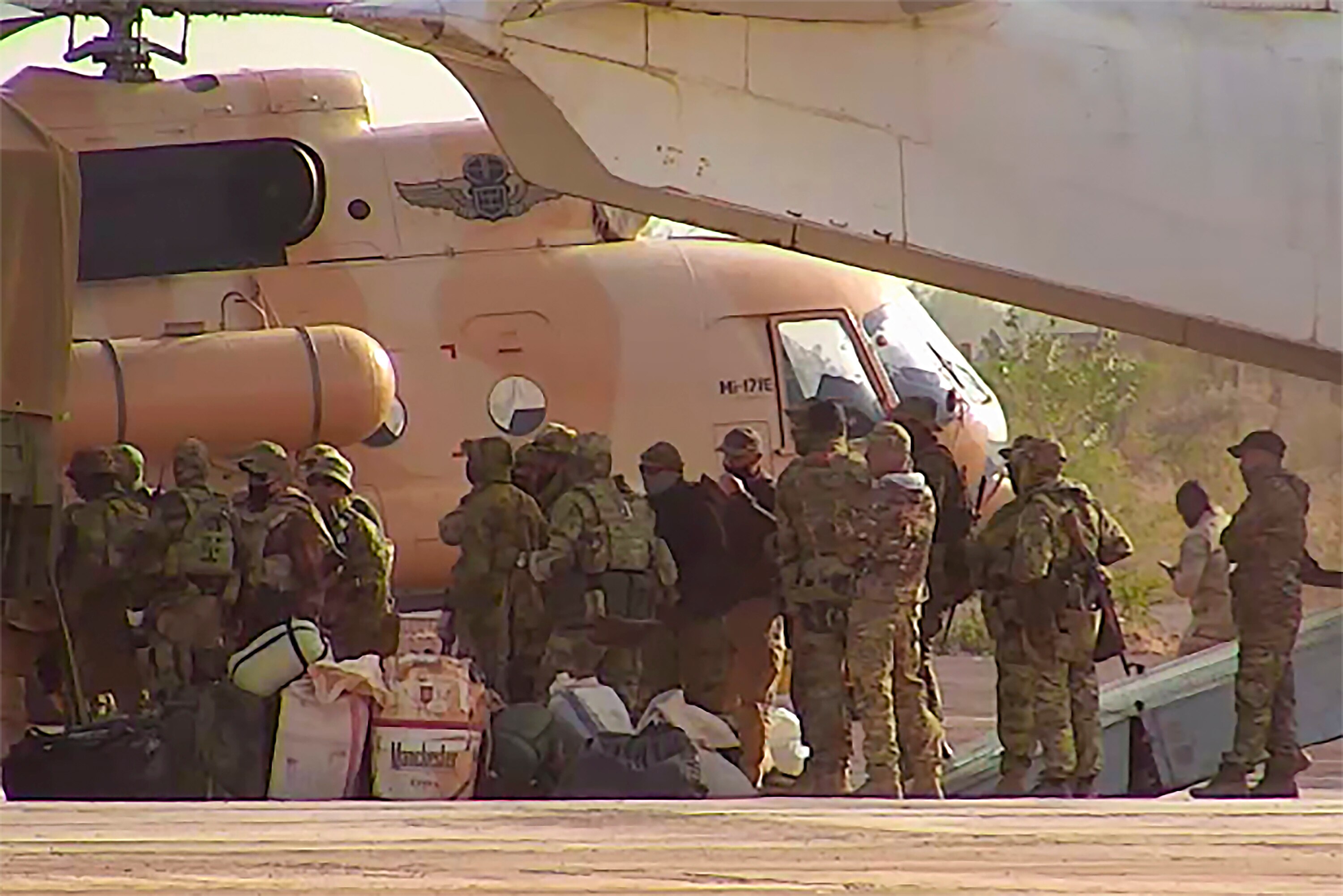 Men in camo gear waiting to board a plane 