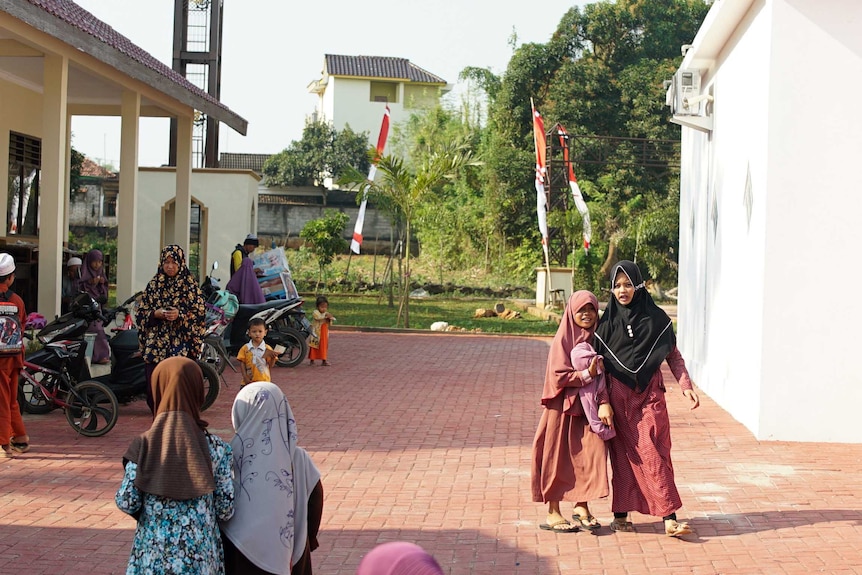 Children walk together in a paved section of the Peace Circle grounds.