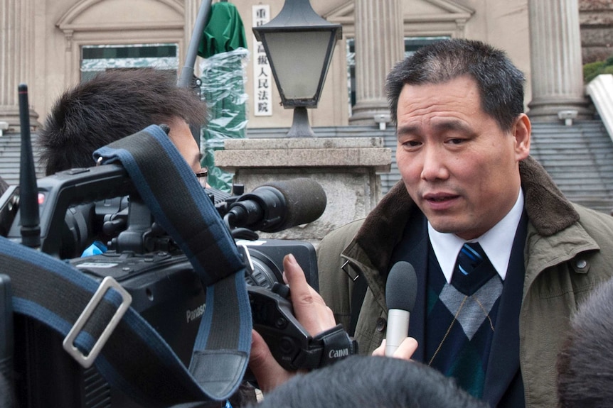 Chinese lawyer Pu Zhiqiang speaks to journalists outside a courthouse.