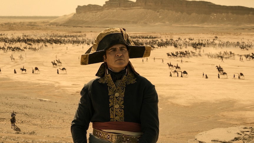 Joaquin Phoenix dressed in military uniform as Napoleon. 