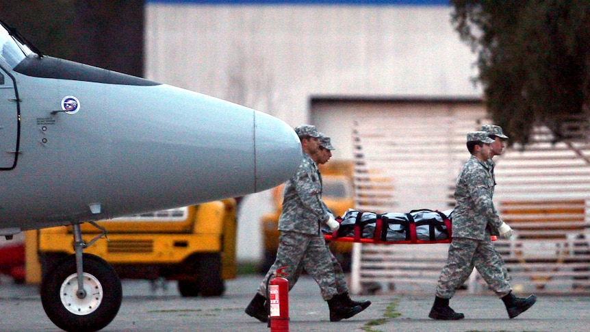 Members of the Chilean Air Force in Santiago carry the body of a victim of a plane crash
