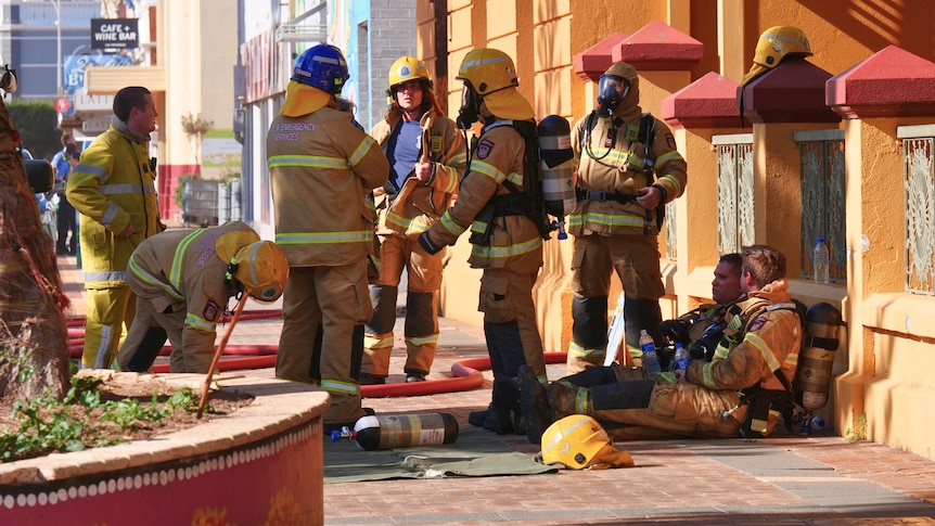 Firefighters outside a building in a country town.