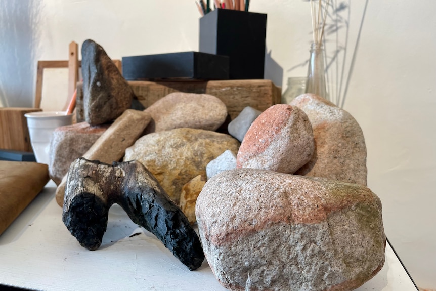 a collection of rocks and charcoal on a table 
