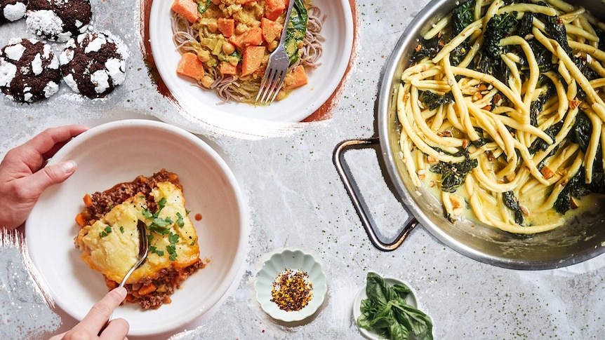 Choc crinkle cookies, pasta, cottage pie, sweet potato curry and basil on a grey table for comfort food recipes.