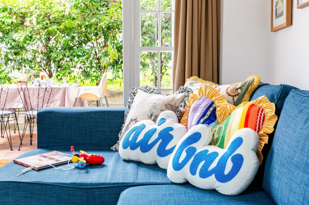 air bnb pillows on a blue couch