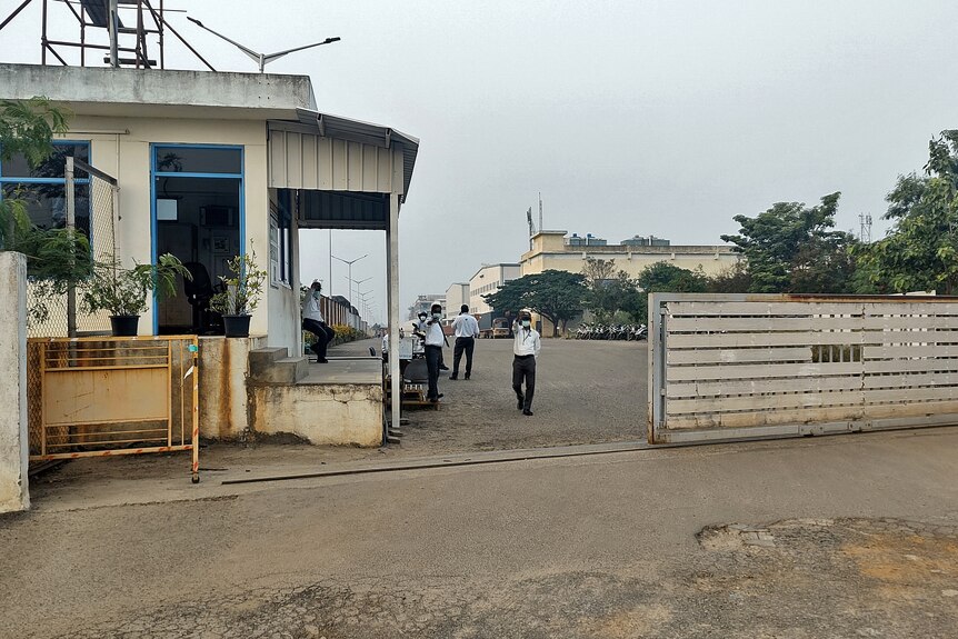 Private security guards stand at the entrance of a closed plant of Foxconn India