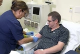 Haemophilia patient Mark Lee receives an injection from a worker at RPA.