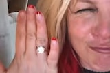 Britney Spears holds her finger, with a large ring visible, up close the camera