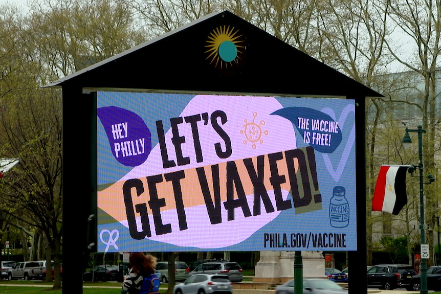A Brightly Colored Sign On A Street In Philadelphia That Says &Quot;Let'S Get Vaxxed&Quot;