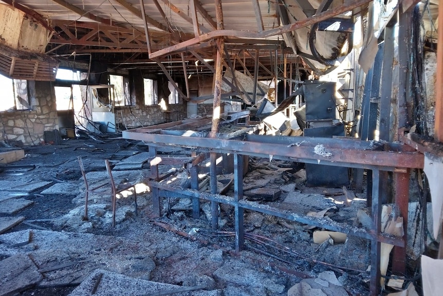 The blackened interior of a pub that has been destroyed by fire.