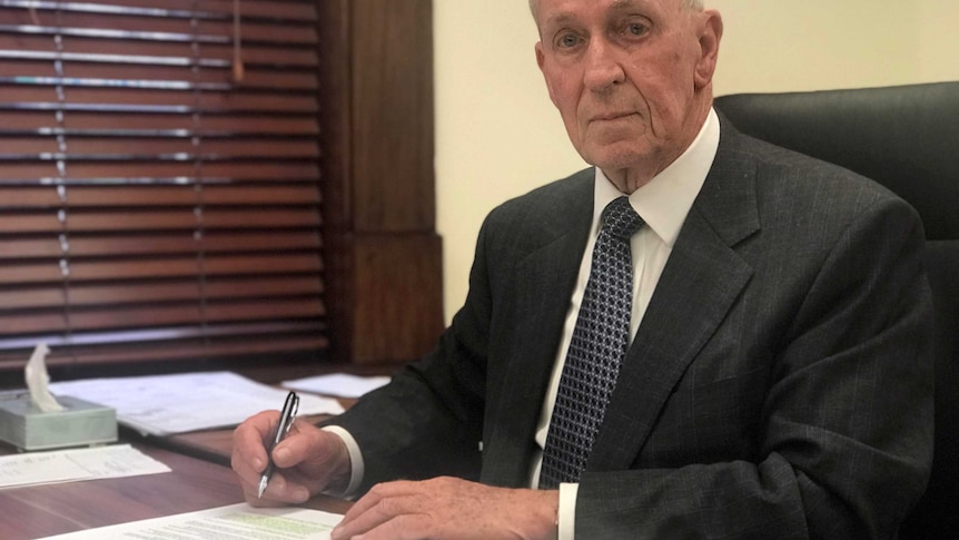 John Darley sits at his desk.