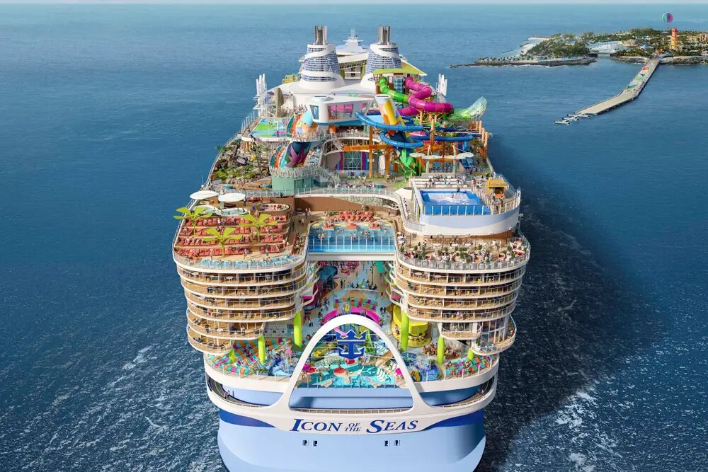 An Icon of the Seas massive cruise ship in the water, with a party on the top deck.