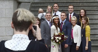 A group wedding photo of an interracial marriage.