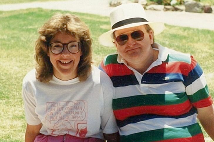 A young man and woman in the 80s smiling at the camera