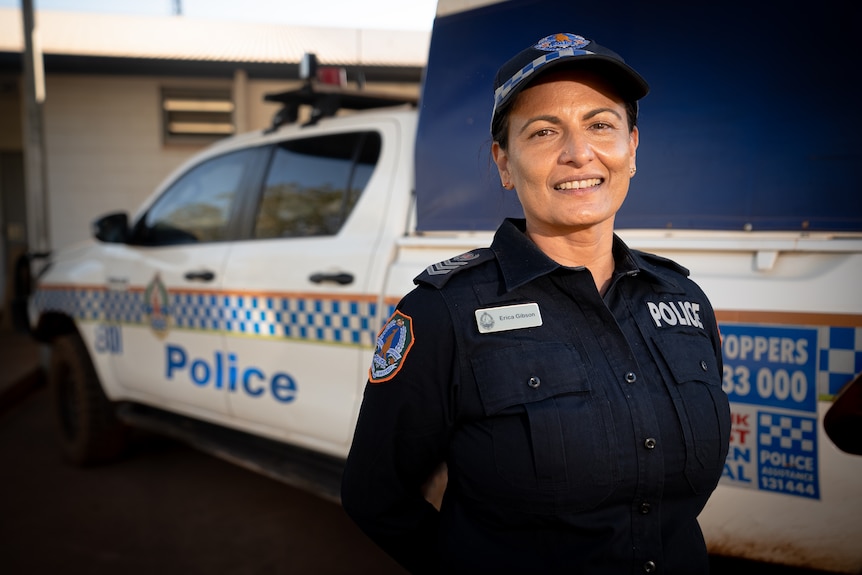 Senior Sergeant Erica Gibson standing in front of a police car.